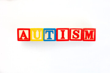 Fototapeta premium Autism spelled out in kids building blocks on plain white background
