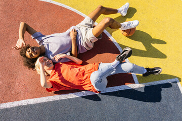 Interracial young couple dating outdoors, colored and modern urban background