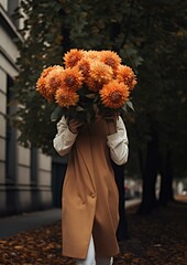 A vertical portrait of a young anonymous girl taking a walk with a beautiful flower bouquet in her hand that covers her face