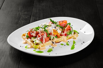 Belgian waffle with avocado, salmon, poached egg and fresh arugula