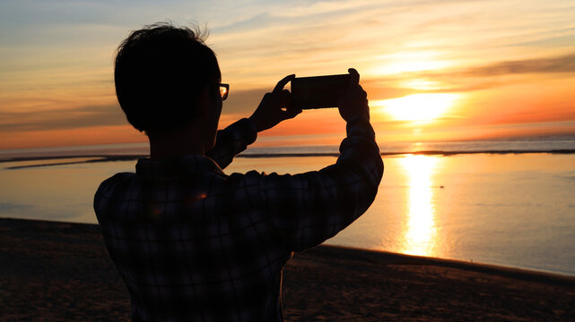 Young tourist man hand using smartphone take picture in summer beach