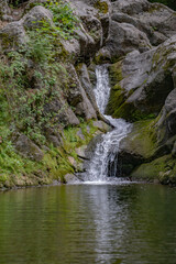 Fototapeta na wymiar Small lake and waterfall. Beautiful waterfall in the forest