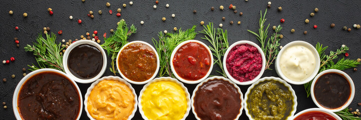 Different types of sauces in bowls with seasonings banner, rosemary and dill, thyme and and peppercorns, top view