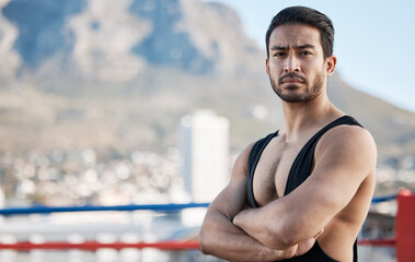Fototapeta na wymiar Man, wrestling and arms crossed in portrait for sport, ring and fitness on rooftop, strong muscle and mindset. Young athlete, serious face and healthy body for fight, mma and training in Cape Town
