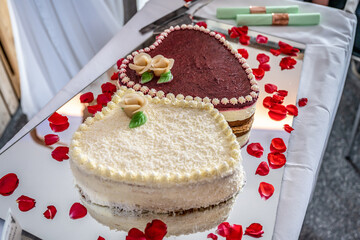 Romantic wedding Two cakes in heart shape, roses bouquet on white table background. Top view