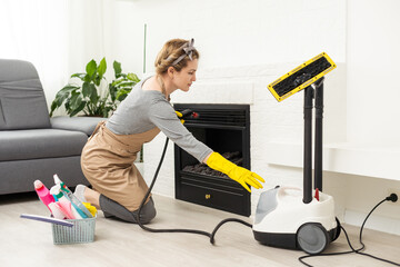 Woman using steam vapor cleaner in living room