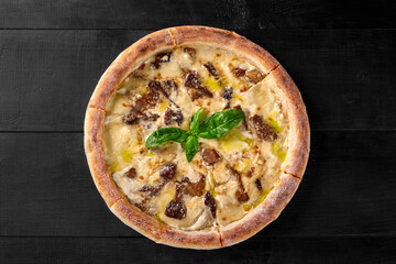 Pizza with cheese sauce, forest mushrooms and champignons garnished with basil