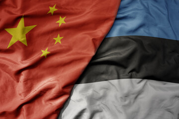 big waving national colorful flag of china and national flag of estonia .