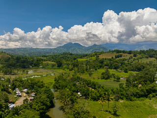 Fototapeta na wymiar Top view of mountains with green forests and agricultural land with farm plantations. Mindanao, Philippines