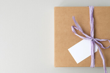 Mockup of a tag on a brown craft box with a ribbon. Space for text, copy space