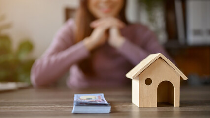 Home investment concept, young Asian girl with house model