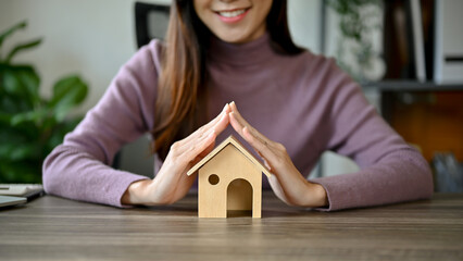 Home investment, young Asian girl with house model planning on buying her house