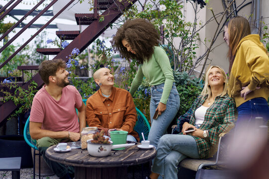 Diverse Group of Students Relaxing on Terrace - Enjoying espresso, cookies, and interactions. - Powered by Adobe