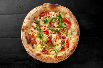Pizza with cheese sauce, salami, bacon, mushrooms, tomatoes and arugula