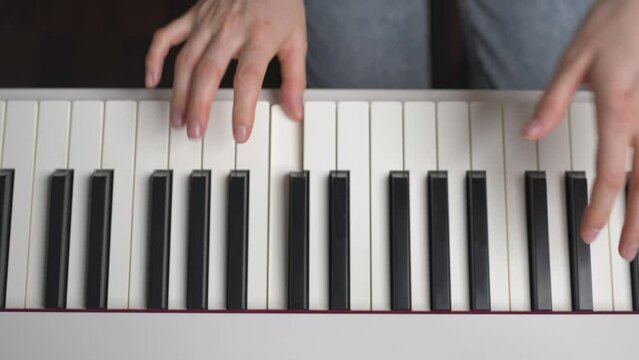Above view of woman playing piano. Camera sliding left