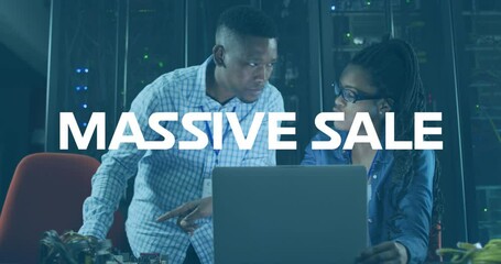 Animation of massive sale text on african american male female engineers using laptop at server room - Powered by Adobe