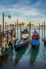Fototapeta na wymiar Gondolas are the symbol of Venice and the San Giorgio Maggiore church in the back