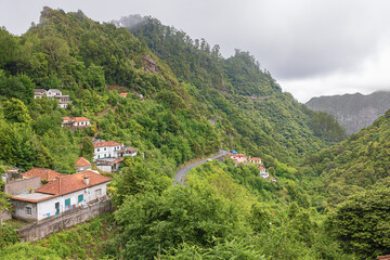 Fototapeta na wymiar Looking down into valley of the Ribeira da Metade from the Levada dos Balcoes offering a short walk between the typical greenery of Madeira’s forest