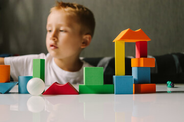 game colored geometric shapes children close-up on the table and the child plays selective focus