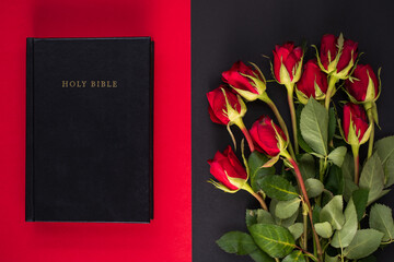 Holy Bible and red roses on the black and red background. Christian concept, believe and faith for...