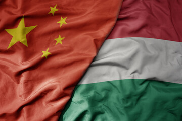 big waving national colorful flag of china and national flag of hungary .