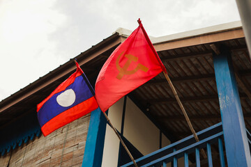 Laos flag and communist party flag decorated on laos people house - obrazy, fototapety, plakaty