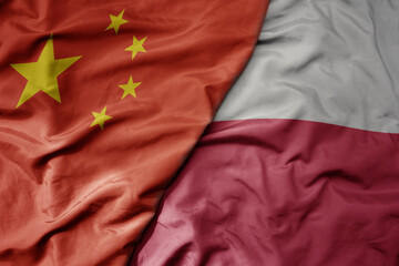 big waving national colorful flag of china and national flag of poland .