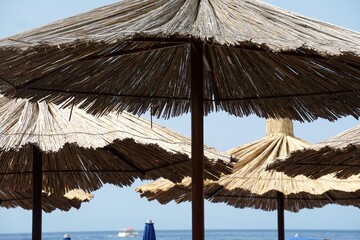 Straw beach umbrellas on the beach by the sea, Straw beach umbrella, Old Budva, Montenegro
