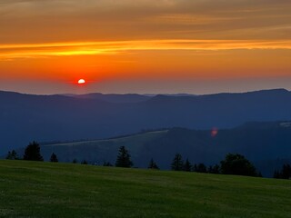 Naklejka na ściany i meble Serene Twilight Symphony: A Spectacular Sunset over the Verdant Vosges Mountains
