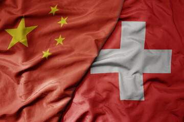 big waving national colorful flag of china and national flag of switzerland .