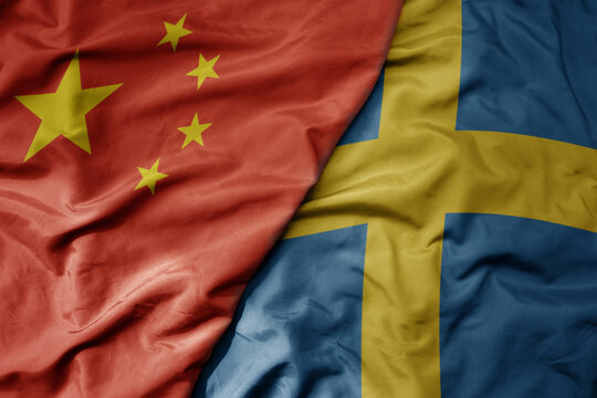 big waving national colorful flag of china and national flag of sweden .