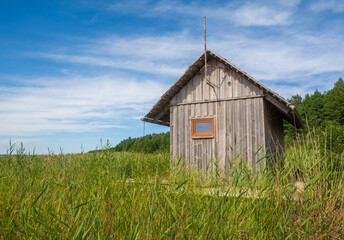 A small wooden house in the reed field of Engure National Park.