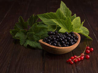 black currant and red currant on a wooden background.