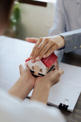 agent hand cover house model. real estate, insurance and property concepts after purchase