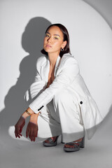 Serious, portrait and fashion with spotlight on woman in studio for makeup, creative and art....