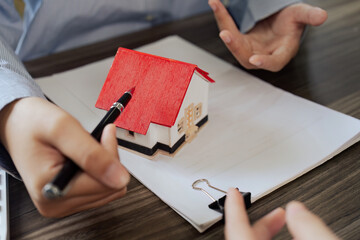 Real Estate Agent and client talking about Property insurance and security concept about house to...