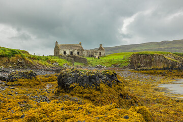 Derelict croft house, used as a cow shed on the Isle of Canna, Scotland on a wet, stormy day with...