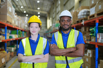 Worker working in large warehouse holding paper chart check list checking the material compare with the boxes wrapped with plastic keep on wooden pallet ready to ship to customer