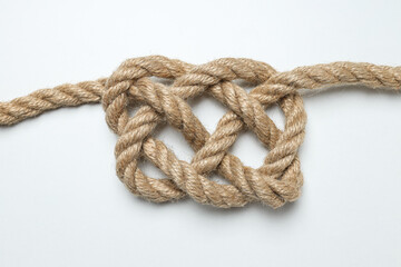 Thick knotted rope close-up on gray background