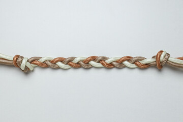 Braided multicolored ropes on a white background. Concept of unity.