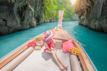 Traveler woman joy fun relaxing on boat at Pileh Lagoon Bay, Phi Phi Island, Krabi, Tourist girl on summer holiday vacation trip, beautiful place, crystal clear emerald waters.