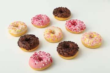 Chocolate, white and pink donuts on white background