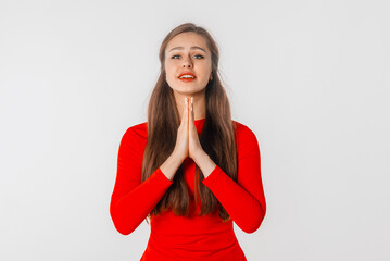 Please. Lovely young woman showing begging gesture, asking for favour, standing over white background. Religious girl praying with calm face, having hope for better future