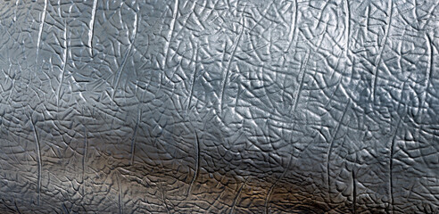 Bright silver abstract artificial leather texture. Imitation of gray dinosaur scales.