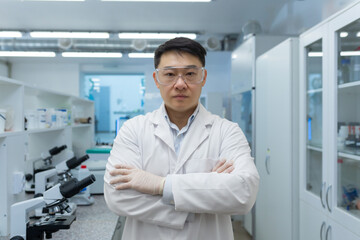 Portrait of serious confident scientist laboratory assistant, Asian man with crossed arms...