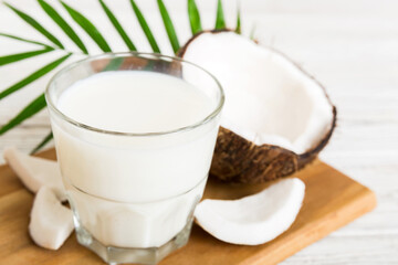 coconut products on white wooden table background. Dairy free milk substitute drink, Flat lay healthy eating