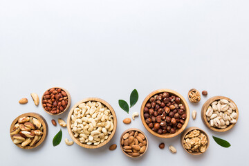 mixed nuts in wooden bowl. Mix of various nuts on colored background. pistachios, cashews, walnuts, hazelnuts, peanuts and brazil nuts