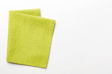 top view with green kitchen napkin isolated on table background. Folded cloth for mockup with copy...