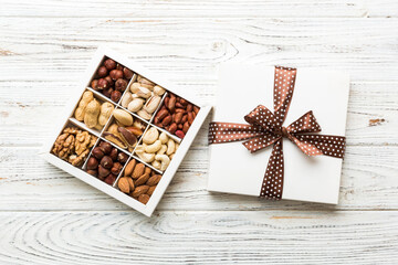 Various varieties of nuts lying in paper box on table background. Top view. Healthy food. Close up, copy space, top view, flat lay. Walnut, pistachios, almonds, hazelnuts and cashews