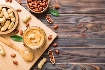 Bowl of peanut butter and peanuts on table background. top view with copy space. Creamy peanut pasta in small bowl